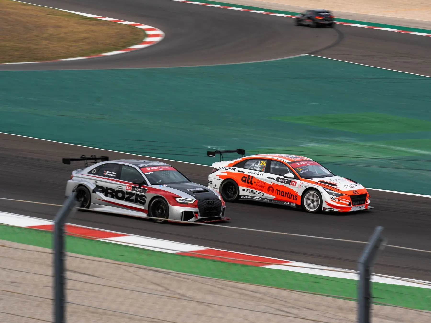 Twee toerwagens naast elkaar door een bocht op het circuit